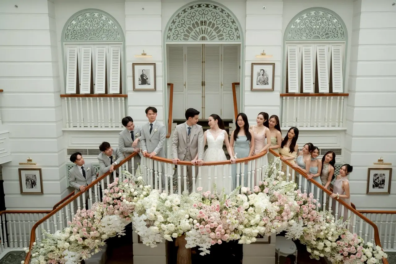 บ่าวสาวและเพื่อนเจ้าบ่าวเจ้าสาวบนบันไดคู่สีขาว ประดับดอกไม้ขาวและชมพู